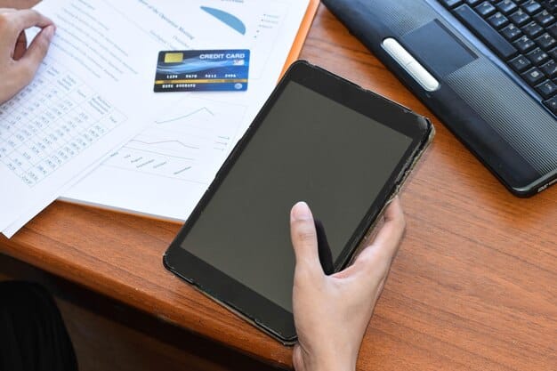 A close-up photograph of a tablet screen displaying a mobile banking app interface, showing a high-yield savings account with details of interest earned and balance, alongside a credit card and a set of keys.