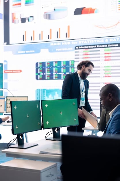 Detailed image of a diverse group of professionals analyzing financial data on multiple screens in a modern office. Charts and graphs showing GDP growth and investment trends are visible on the screens. The image conveys a sense of data-driven decision-making and professional expertise.