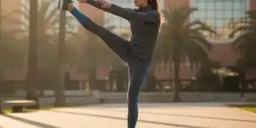 Atleta realizando estiramiento dinámico para prevenir lesiones deportivas en un parque urbano español.