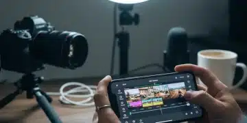 Manos editando un vídeo en un smartphone, con herramientas de edición en pantalla y un fondo creativo.